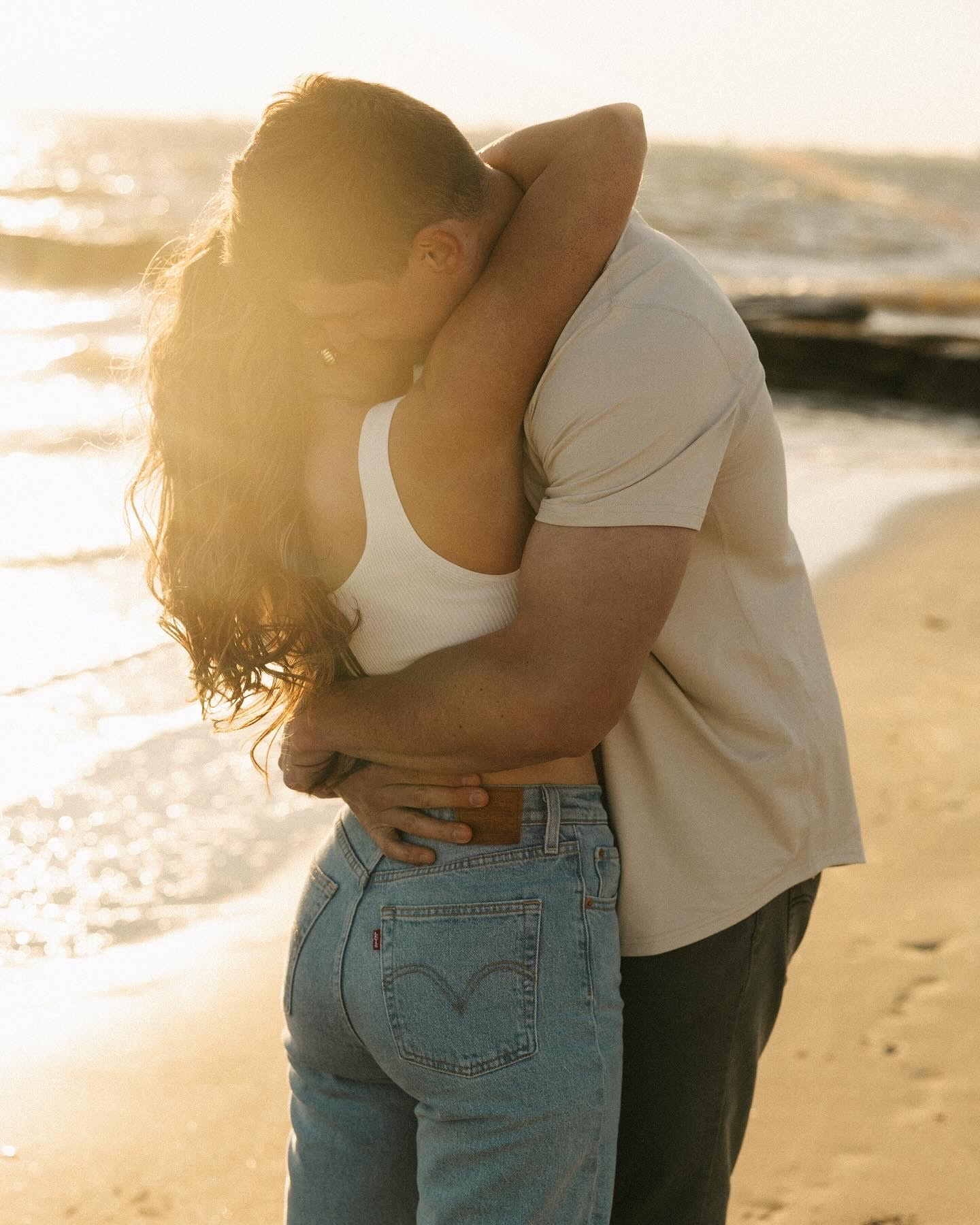 A happy couple embrace tightly on a beach at one of the Charleston wedding venues