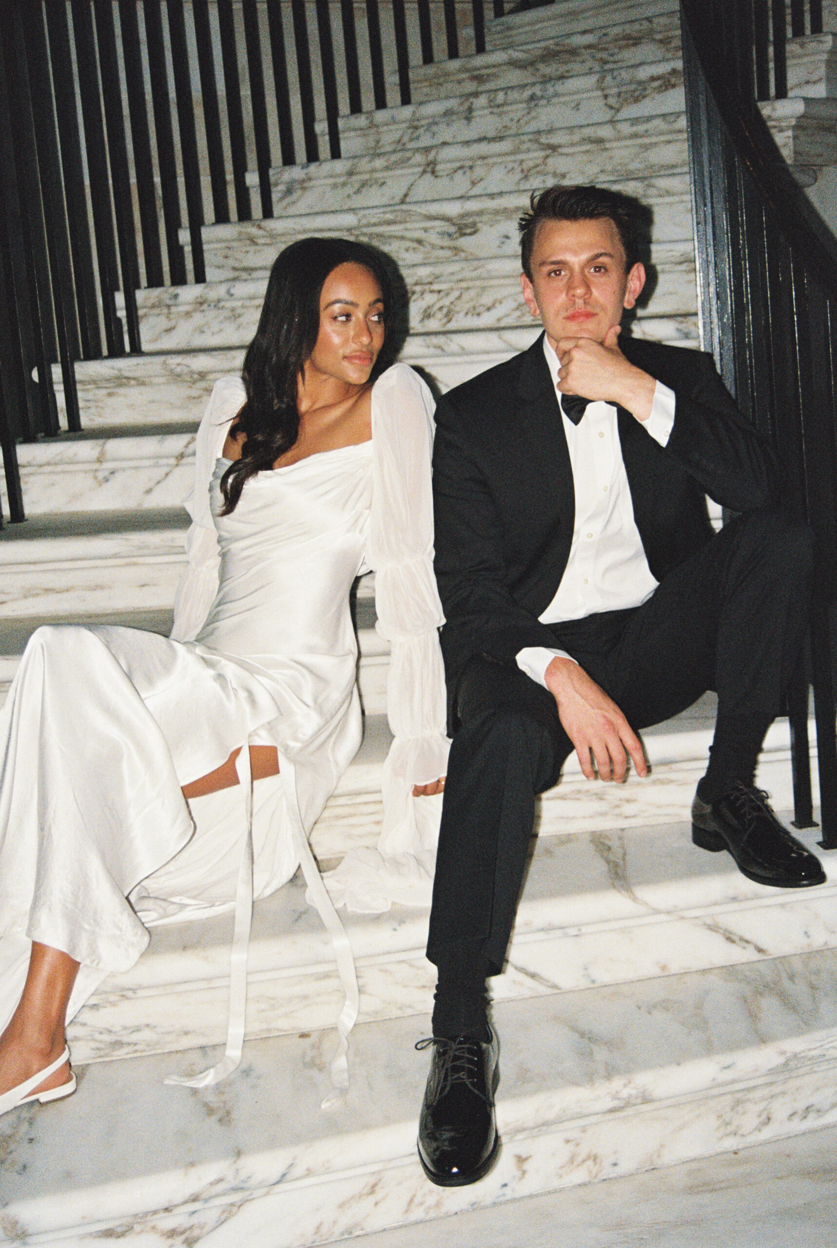 Newlyweds sit and relax on a marble grand staircase of one of the Charleston wedding venues