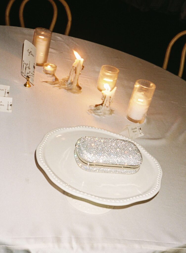 Details of a diamond covered case on a plate with candles