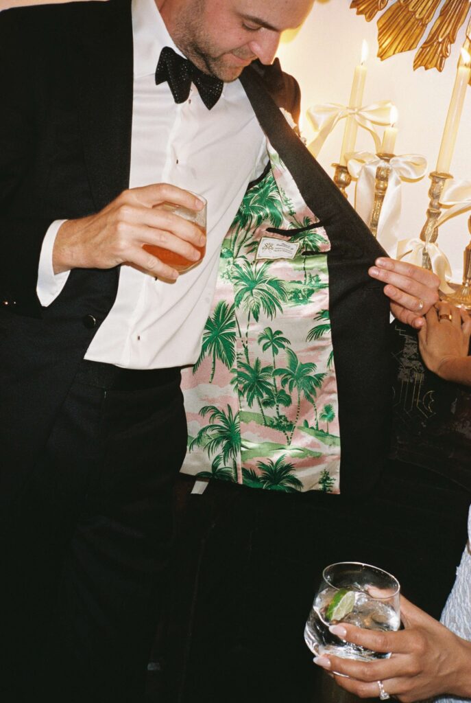 A groom shows off his custom palm tree liner of his suit jacket