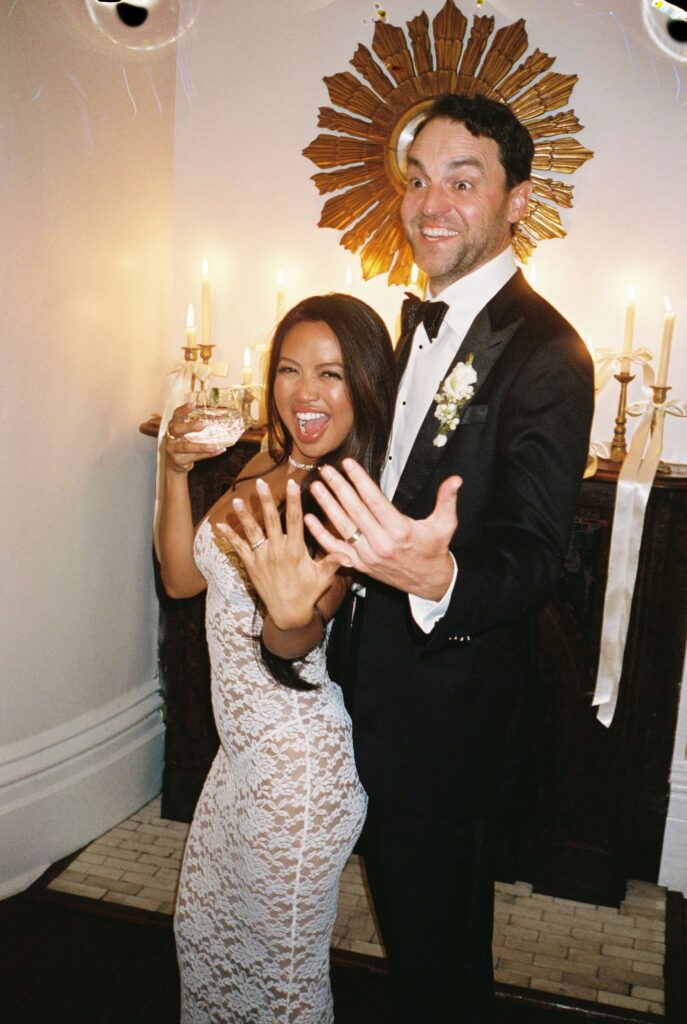 Newlyweds show off their rings while dancing with cocktails
