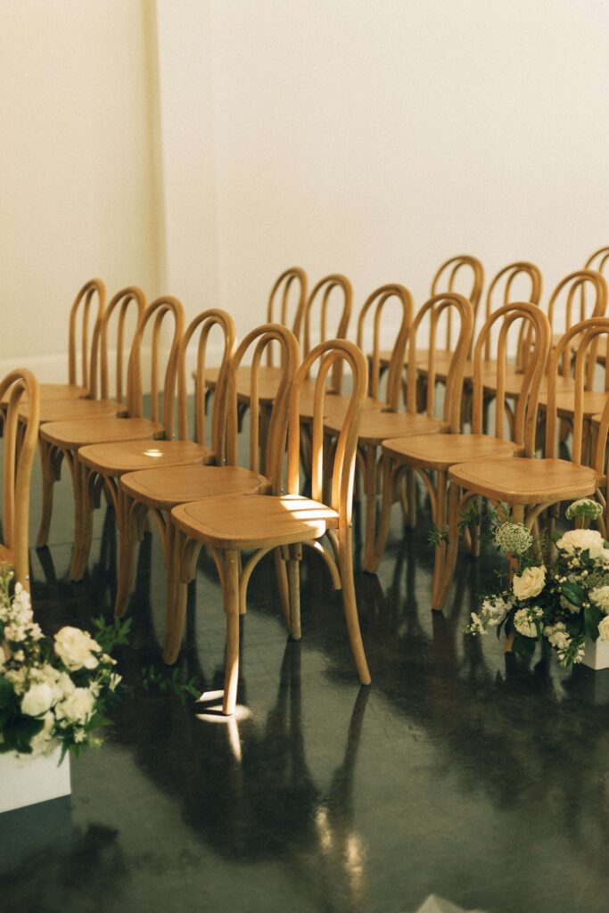 Details of wedding ceremony chairs set up with white flowers at the merrimon wynne house wedding venue