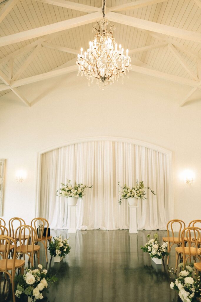 Details of the merrimon wynne house wedding ceremony space with exposed beams and chandelier