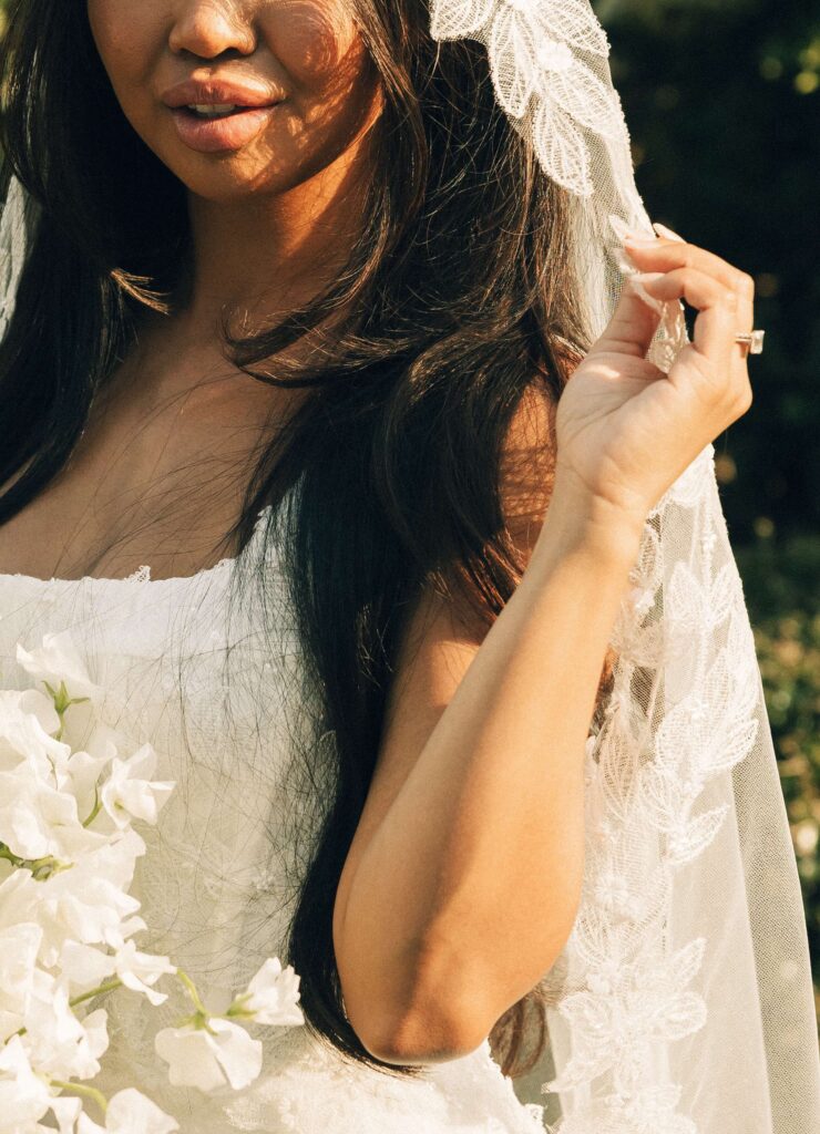 Details of a bride holding her lace embroidered veil