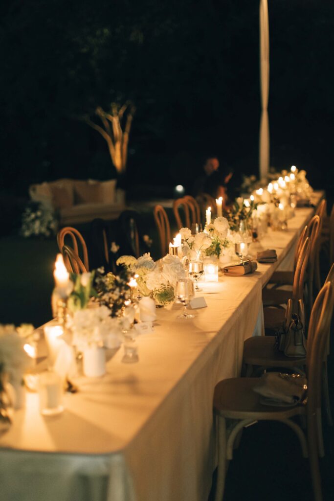 Details of a long outdoor merrimon wynne house wedding reception table with white linen and candles