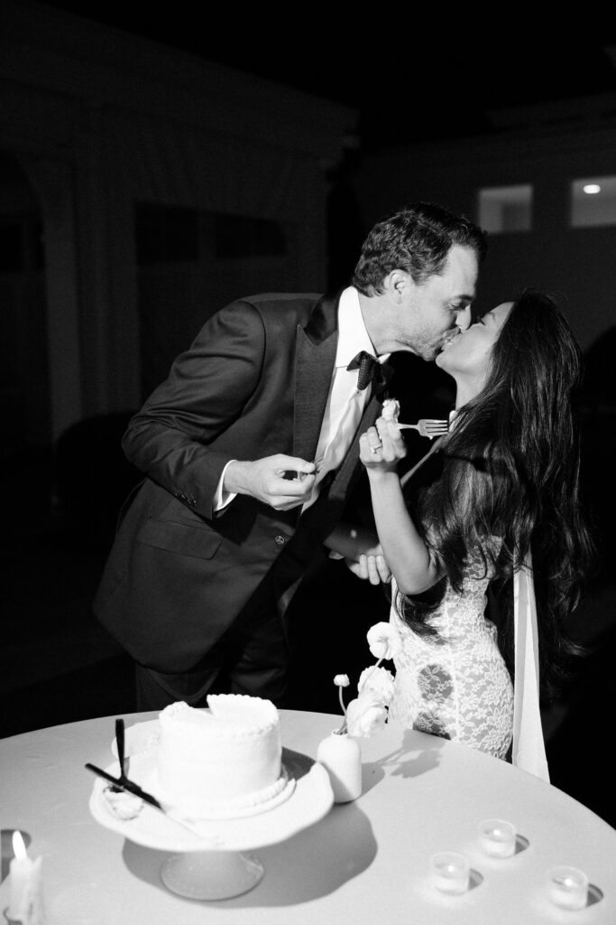 Newlyweds kiss while cutting the cake