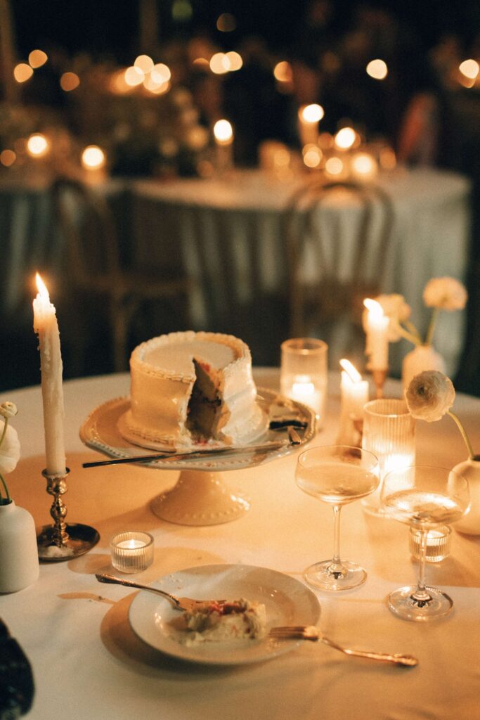 Details of a cake sliced on a table with candles at the merrimon wynne house wedding venue