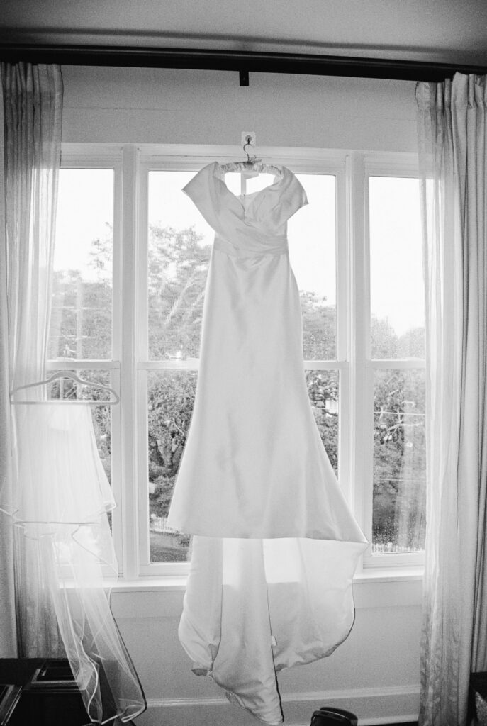 A wedding gown hangs in a window waiting to be worn for a Post House Inn wedding