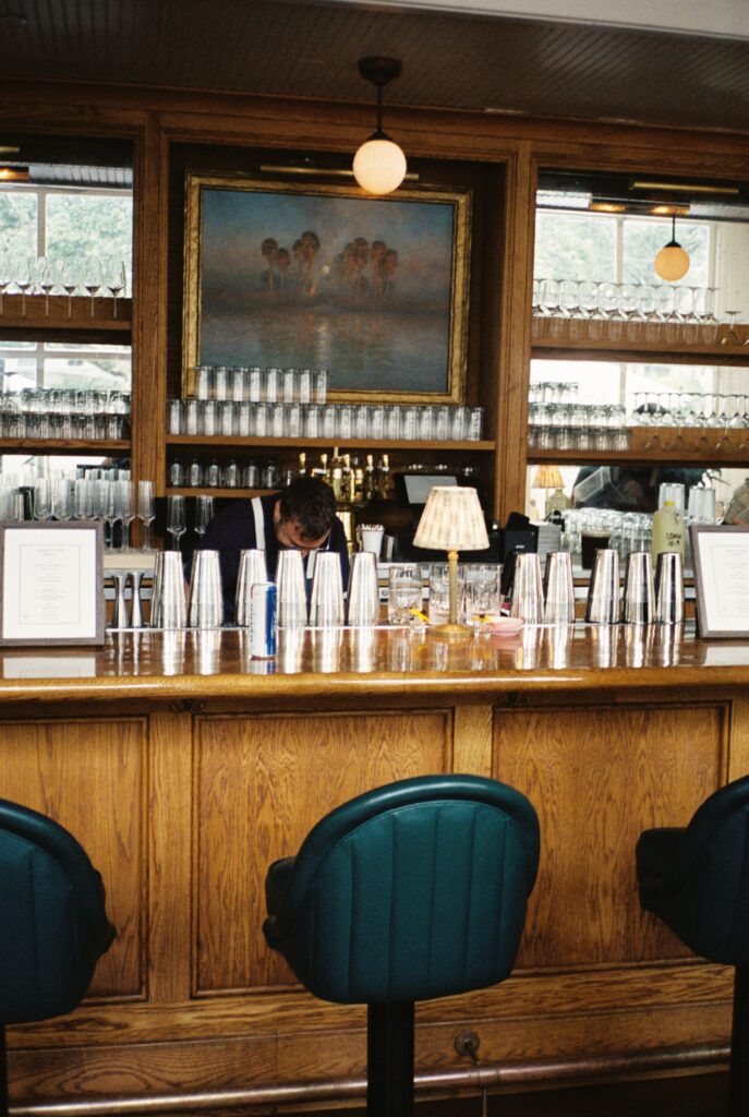 Details of the vintage hardwood bar set up with chairs at the Post House Inn wedding venue