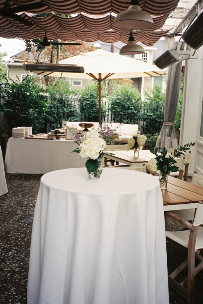 A look at cocktail hour set up on the patio under umbrellas