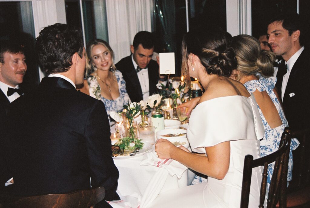 A bride and groom sit and chat over dinner with their wedding party at a Post House Inn wedding reception