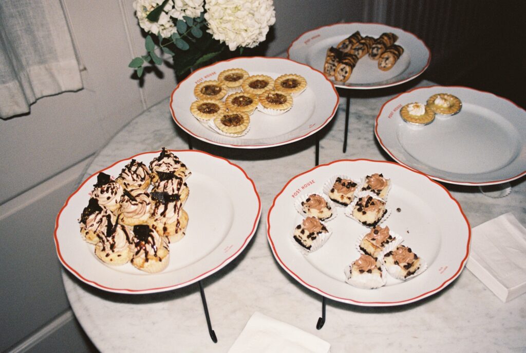 Details of a desert table with various pastries on plates on a marble table at a Post House Inn wedding