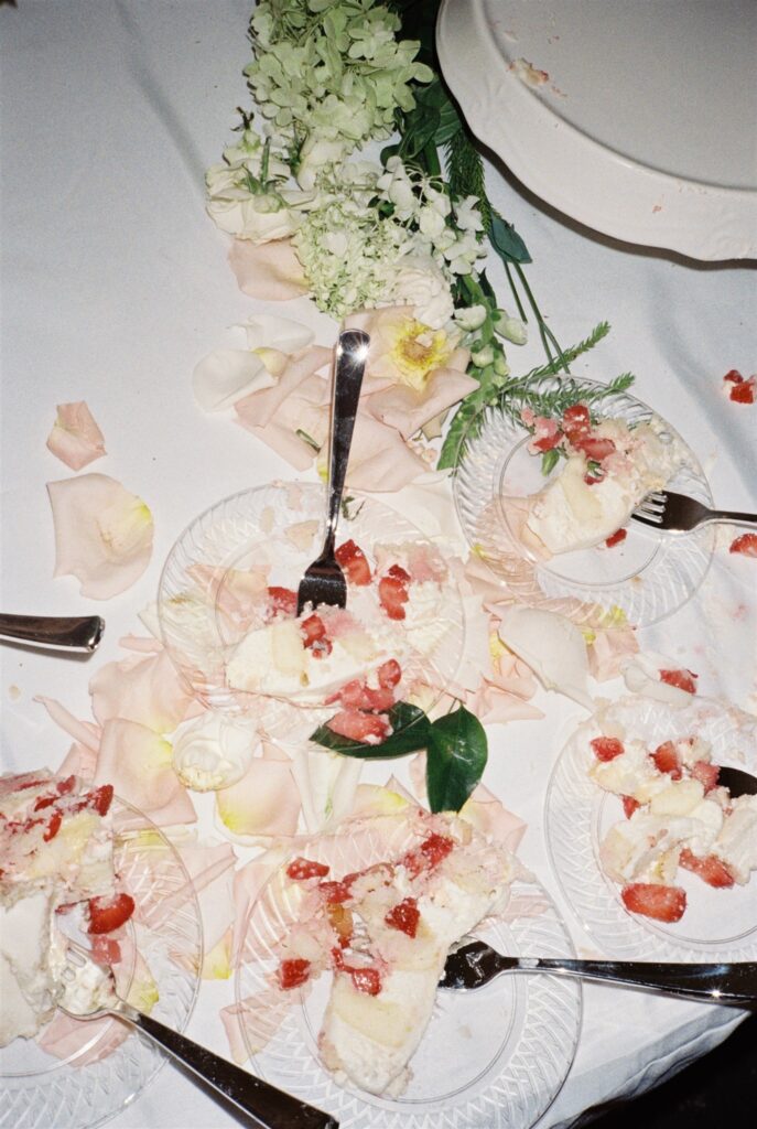 A look down at wedding cake with strawberries and forks on plates