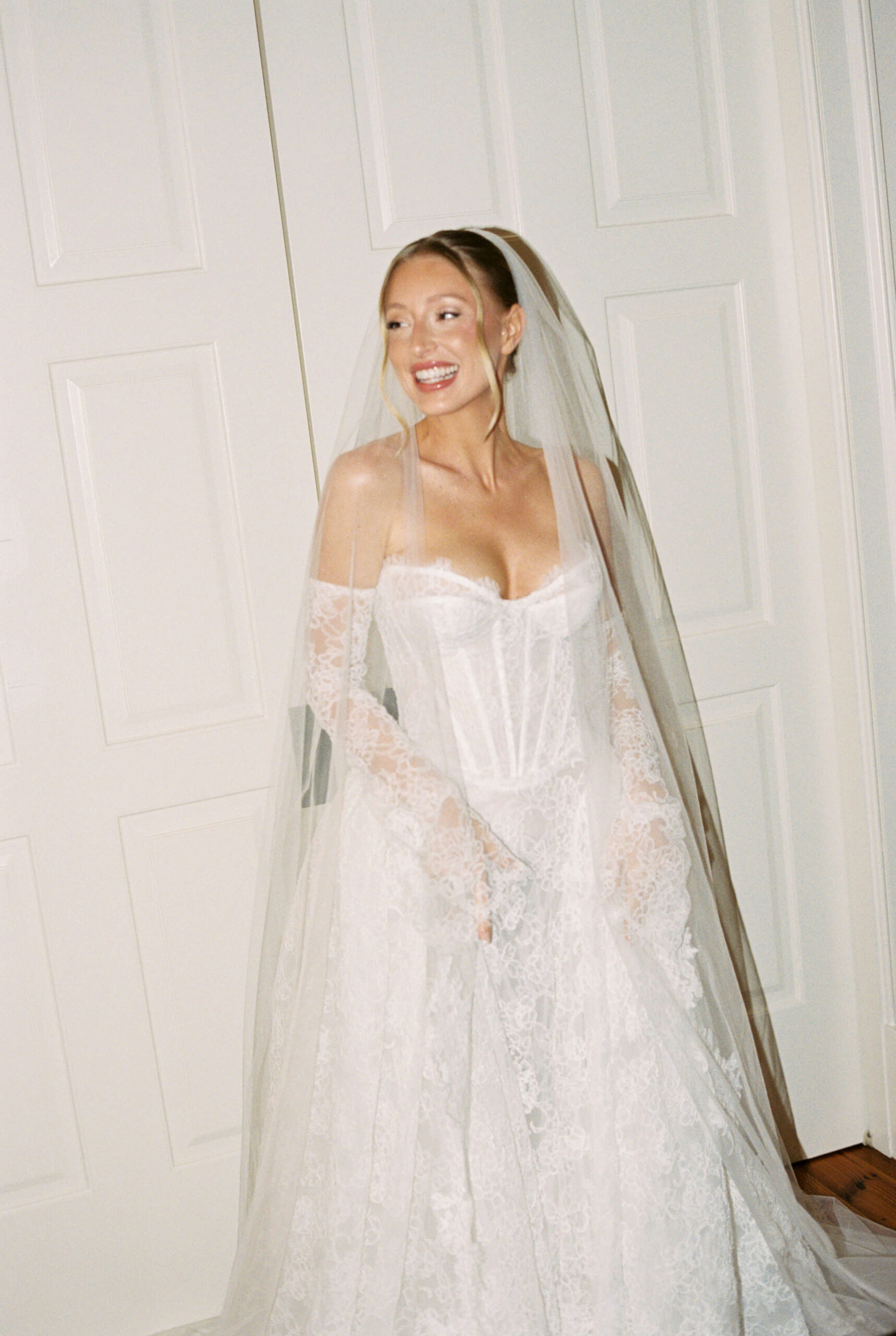 A bride laughs while in her gown getting ready