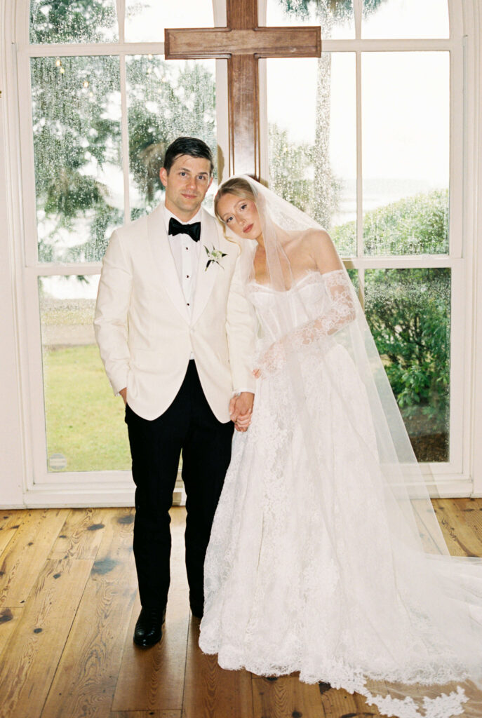 A bride leans on the shoulder of her groom in his white tux jacket at the altar of their montage palmetto bluff wedding ceremony