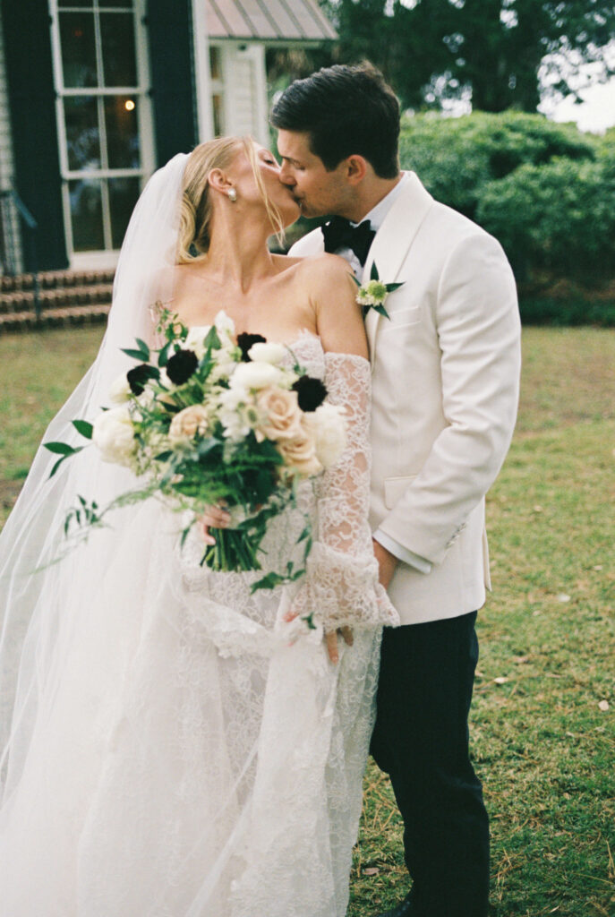 Newlyweds kiss in a lawn outside the montage palmetto bluff wedding venue