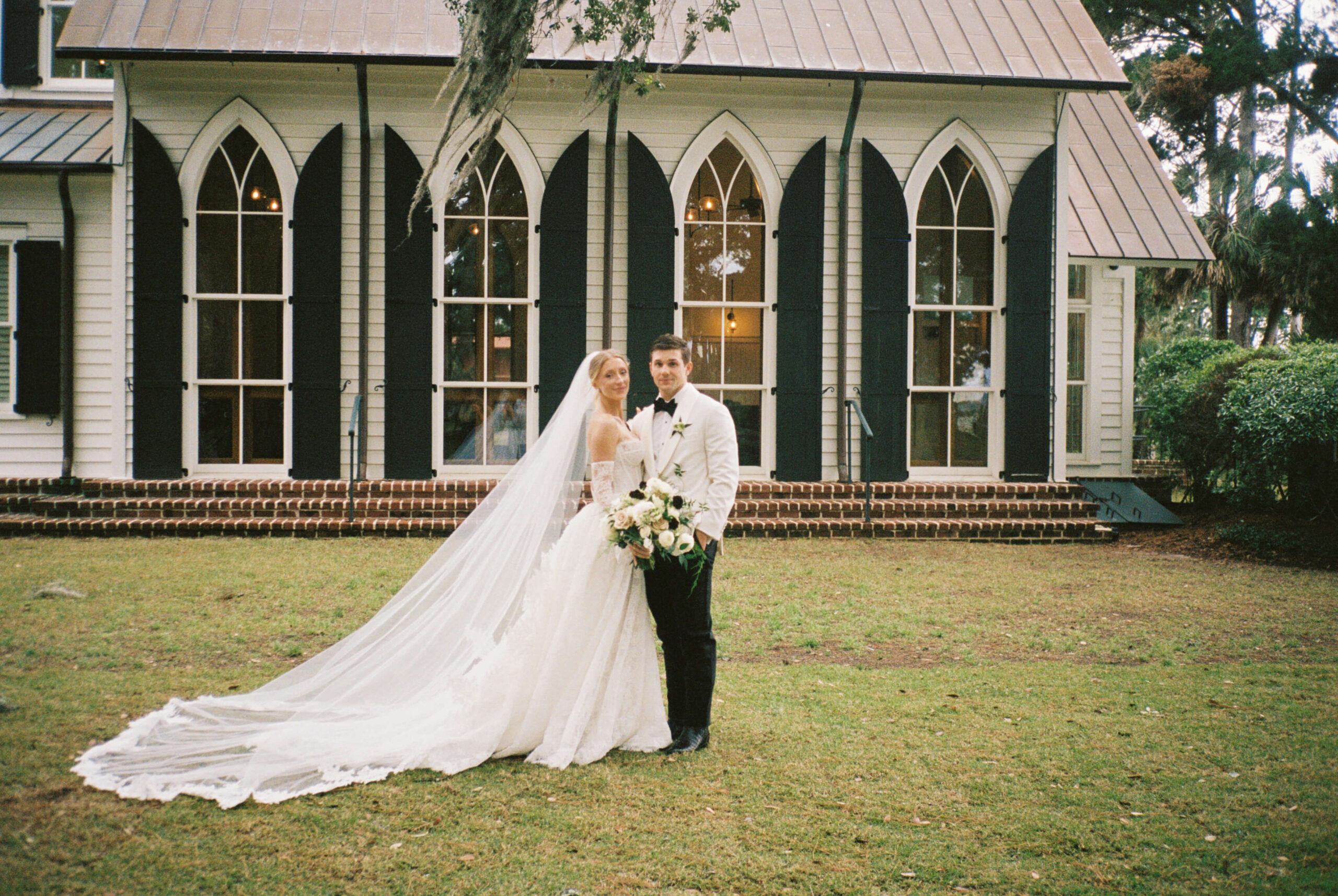 A bride and groom smile while standing in the lawn of the montage palmetto bluff wedding