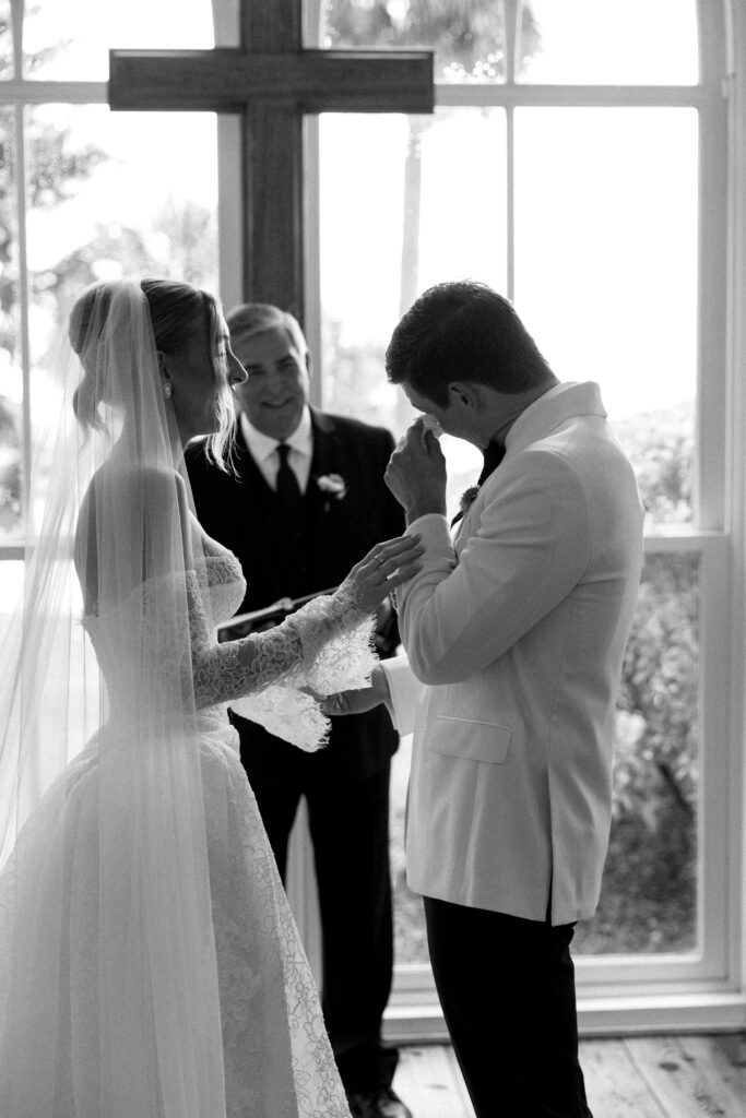 A groom wipes away tears during his ceremony in black and white