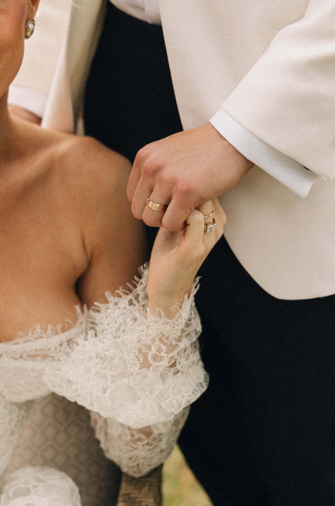 Details of newlyweds holding hands with their ring hands