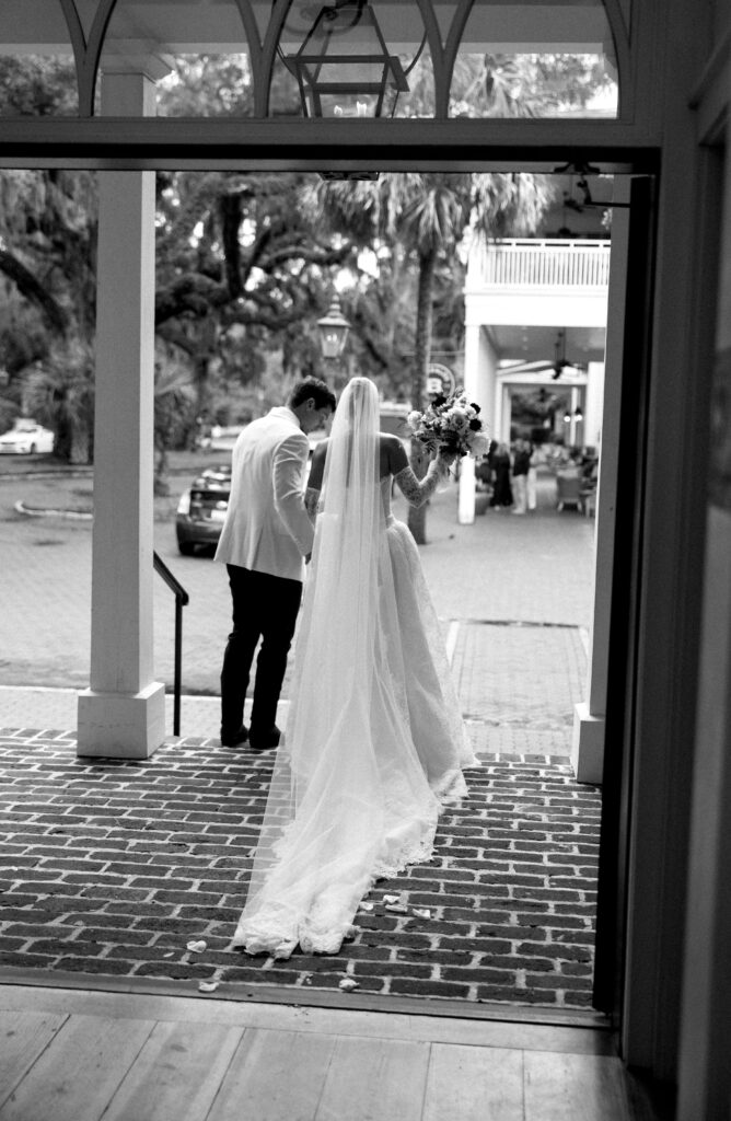 A groom helps his bride down the church steps after their ceremony at the montage palmetto bluff
