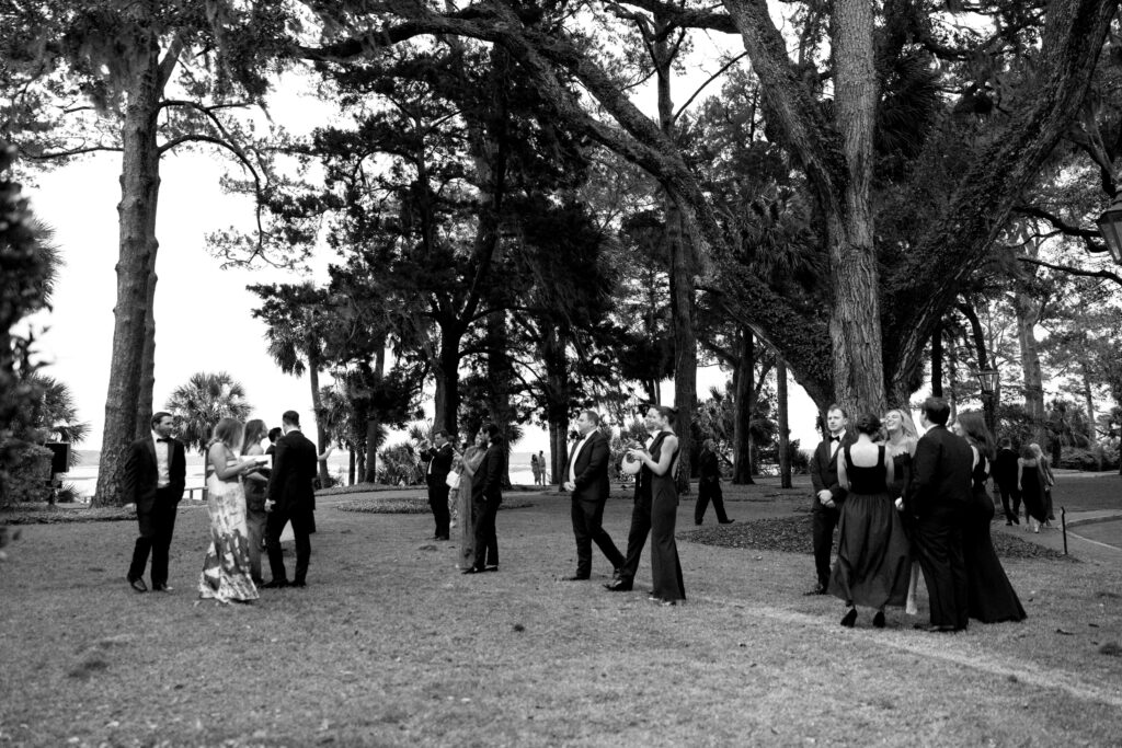 Wedding guests make their way from a ceremony to a cocktail hour through the lawn of the montage palmetto bluff