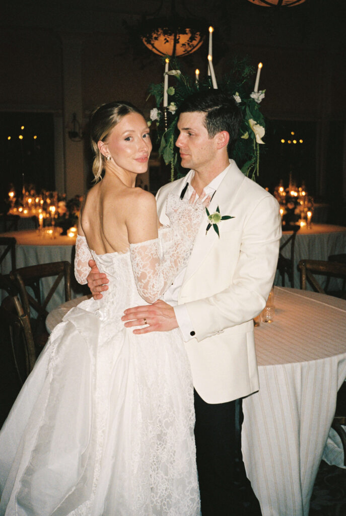 Newlyweds snuggle against a reception table at the montage palmetto bluff with large candle centerpiece